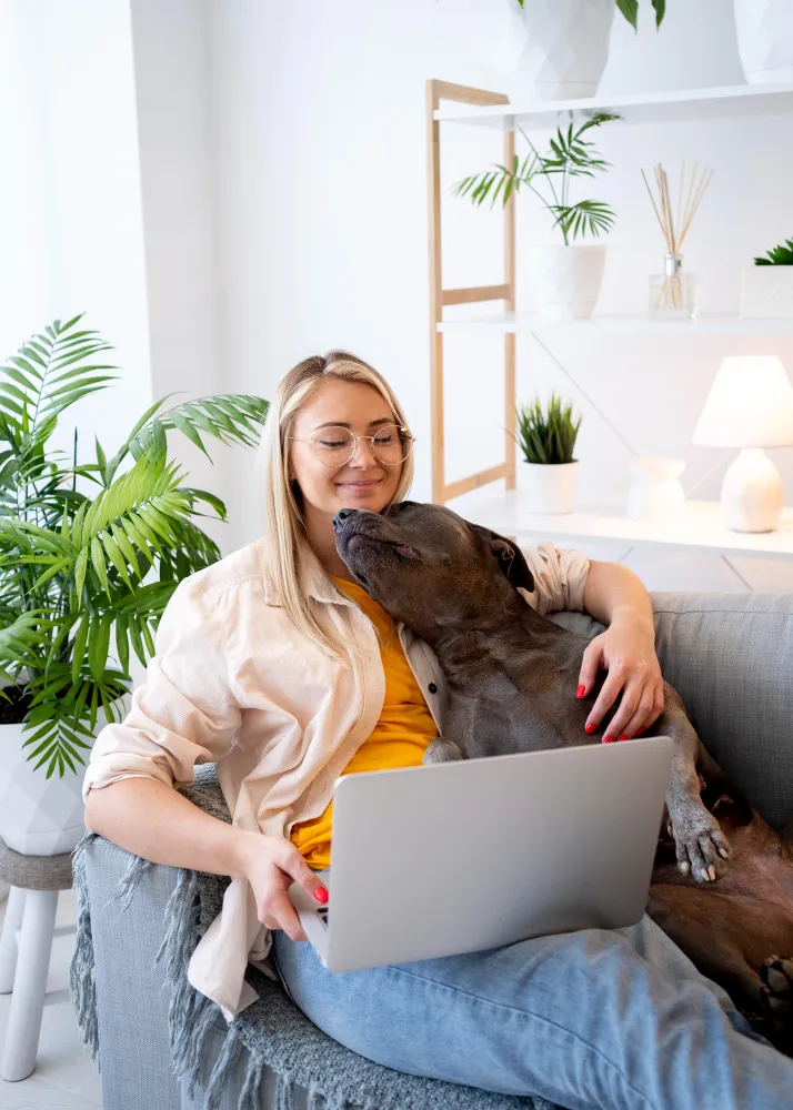 Woman in her apartment with her emotional support dog resting beside her